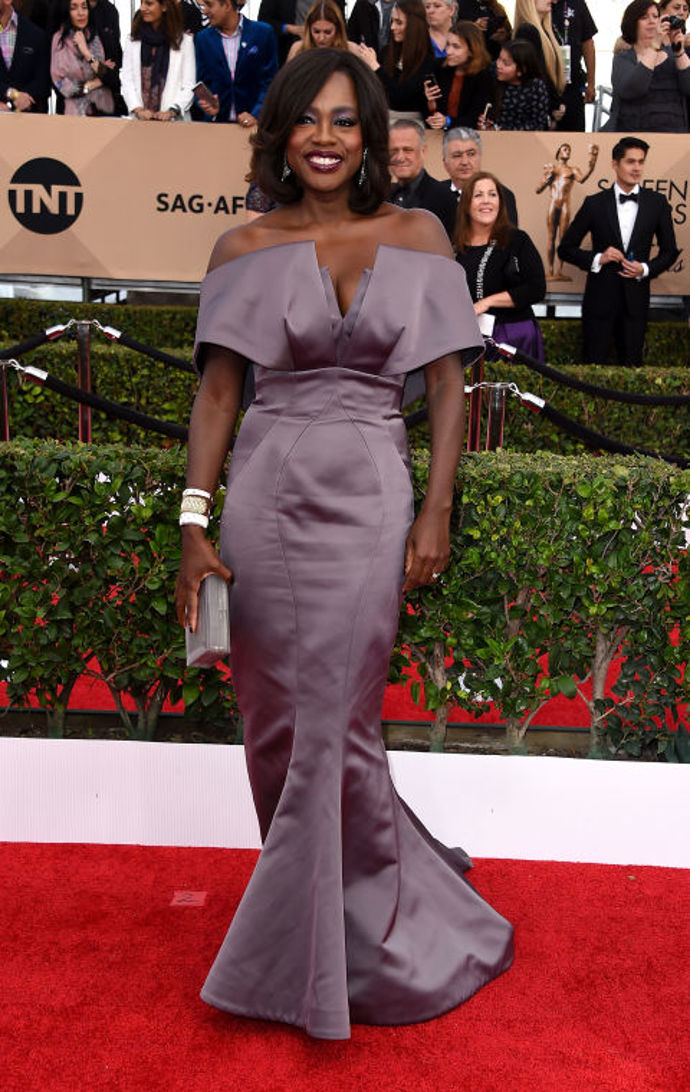 Střihově zajímavou róbu měla herečka Viola Davis. Metalické fialové šaty Zac Posen lichotily hereččině  postavě a odhalená ramena jí ubrala několik let. Líbí se nám i výrazný bílý náramek, který vše ještě trochu oživuje.