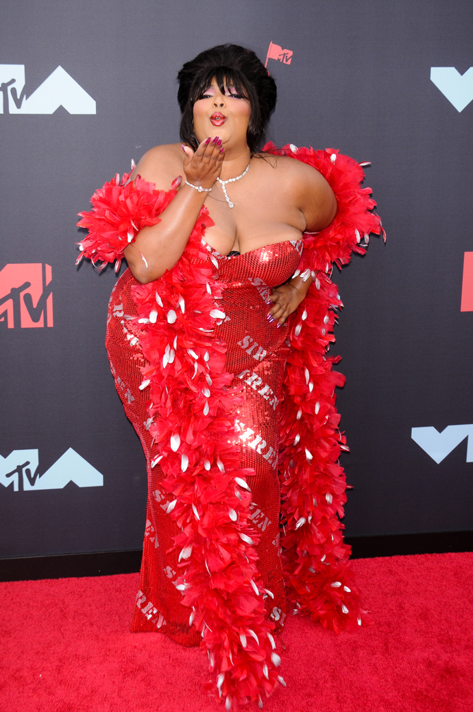 Lizzo

Na předávání cen MTV VMAs v na míru šitých šatech Moschino. 
