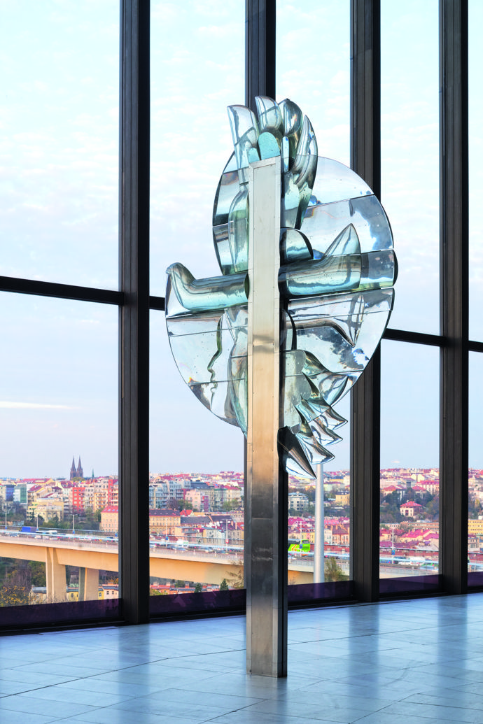  

Monumentální plastika od Stanislava Libenského a Jaroslavy Brychtové dominuje foyeru s výhledem na nedaleký Nuselský most a okolní městskou zástavbu. Velkorysý krytý veřejný prostor sahá přes celá tři patra. 
