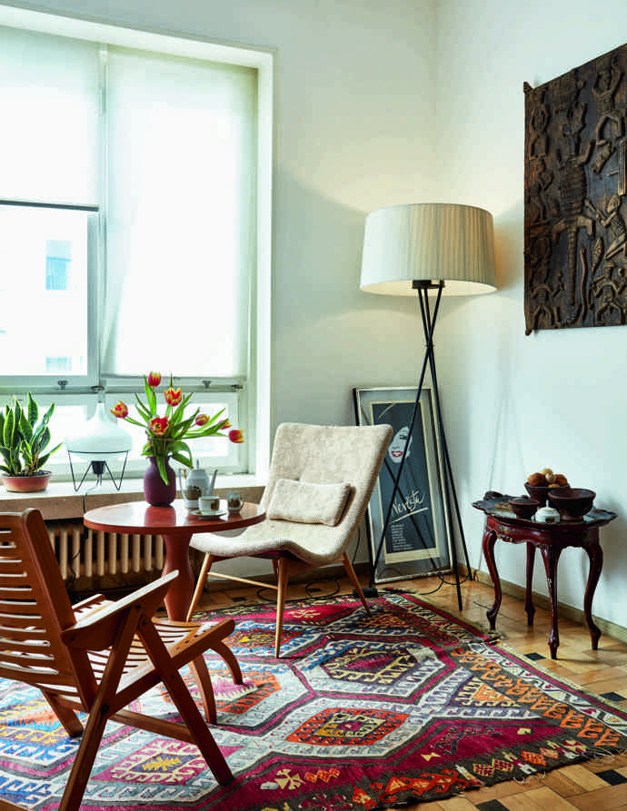  

Nomádský koberec kilim je starožitnost dovezená z Istanbulu, u kávového stolku s vázou od Romana Šediny a setem Louise od Jaroslava Ježka se sedí na skořepinovém křesle Miroslava Navrátila nebo ikonické skládací židli Rex od slovinských Rex Kralj. Atmosféru vytváří stojací lampa Tripod španělské firmy Santa & Cole a stolní lampička z antikvariátu. Plakát je od kamaráda z Dominikánské republiky pro jedno z prvních Urošových představení na DAMU. Nad tereziánským retro garni stolečkem z roku 1860 jsou zdobené dřevěné dveře z Nigérie, které zde tradičně vedou do hliněných domků. 
