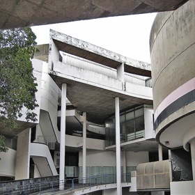  

Werdmuller Centre, 1975

Dnes uzavřené obchodní středisko Werdmuller stále vyvolává rozporuplné emoce a poslední roky čelí hrozbám demolice. Té se odborná veřejnost snaží zabránit a poukazuje na nesporné kvality stavby. Architekt Roelof Uytenbogaardt v ní experimentoval s otevřeným prostorem, rampami ze surového betonu a dramatickými světelnými průhledy. Struktura měla navodit dojem otevřeného tržiště pro zákazníky všech kultur, do myšlenky ale zasáhlo prohlášení čtvrti za striktně bělošskou a nucené vystěhování zbytku obyvatelstva.
