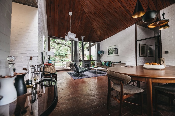  

House Raynham, 1967

Za manželským párem Gwen a Gawiem Faganovými stojí přes pětačtyřicet let společné architektonické práce. V Kapském Městě realizovali řadu projektů, včetně vlastního ikonického domu nad oceánem. Jejich styl je typický přirozeným začleněním staveb do divokých přírodních podmínek Kapského poloostrova, jenž se vyznačuje extrémním počasím, horkem, větrem a častými požáry. House Raynham na první pohled upoutá zakřivenou a místy výrazně zkosenou měděnou střechou, jejíž tvar se podepisuje i v interiéru domu.
