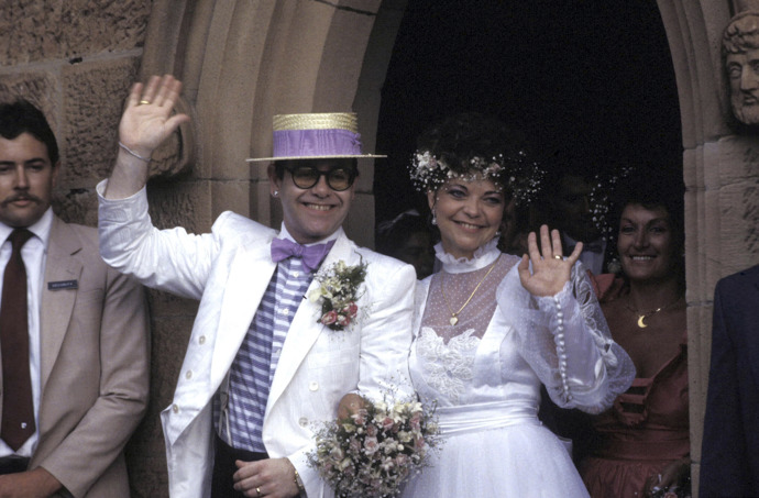  

Elton John a Renate Blauel

Jen málokdo už si asi vzpomene na německou zvukařku Renate Blauel, se kterou se sir Elton John oženil na Valentýna roku 1984 v Sydney. Manželé byli celé čtyři roky, i když Renate později přiznala, že věděla, že je Elton homosexuál. Po rozvodu v roce 1988 se odstěhovala zpět do Německa a Elton se později oženil s Davidem Furnishem, se kterým společně vychovávají syny Elijaha a Zacharyho. Renate o sobě dala znovu vědět v roce 2019, kdy vstoupil do kin Eltonův životopisný film Rocketman, jenž ukazuje i podrobnosti jejich manželství. Renate označila film za klamavý a zažalovala zpěváka o téměř devadesát milionů korun.
