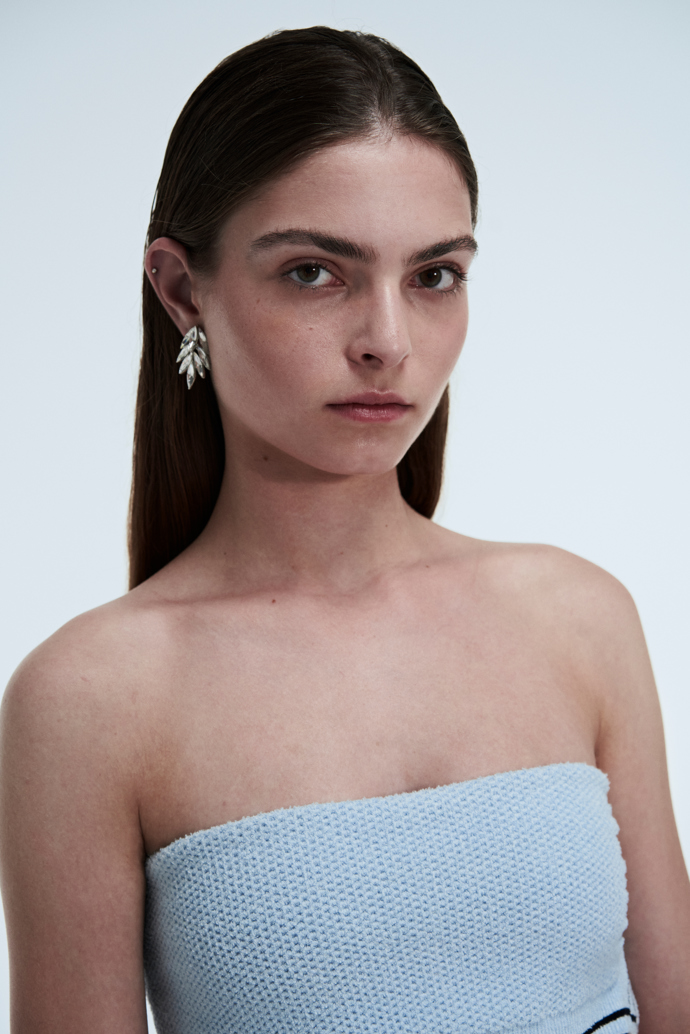 Top a sukně, JACQUEMUS; boty, MIUMIU; náušnice, SWAROVSKI
