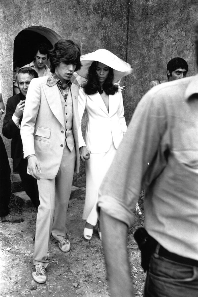 Bianca Jagger

Herečku Biancu Jagger zdobil 12. května 1971, v den její svatby s Mickem Jaggerem v St. Tropez, bílý set od Yvese Saint Laurenta. Šikmá sukně a sako Le Smoking diskrétně skrývaly její bříško, protože byla v té době ve čtvrtém měsíci těhotenství. Nevěstin slonovinový klobouk se širokou krempou také udával trendy jako náhrada klasického závoje. Zkrátka přelomové.
