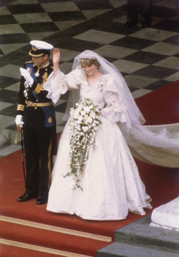 Princezna Diana

Šaty ve slonovinové barvě s taftem, které měla na sobě během svatby s princem Charlesem 29. července 1981 princezna Diana, se do dějin bezesporu zapsaly jako jedny z nejikoničtějších svatebních šatů století. Navržené byly Davidem a Elizabeth Emanuelovými, tvorba jim zabrala dlouhé měsíce. Ručně vyšívané flitry, krajky a 10 000 perel, odhaduje se, že tento umělecký kousek vyšel královskou rodinu na něco kolem 115 000 dolarů. Jejich 25 stop dlouhá vlečka se stala tou nejdelší v historii královských svateb. 
