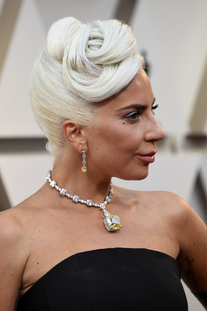  

Účes ve stylu Audreycore. Lady Gaga vyčesala elegantní drdol s pokládanými prameny ofiny. 

