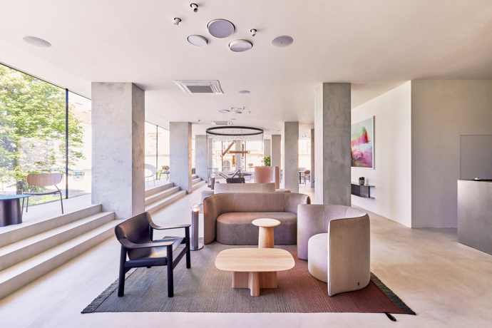  

Lobby hotelu Perk zdobí koberce od přední španělské značky Nanimarquina v tlumených barvách a venkovním provedení, křesla od dánské firmy +Halle a prvky vyrobené na míru od Formdesign spolu s kusy, které navrhla sama Lucie Koldová – křesílko Cocon pro Master & Master, kávové stolky XX pro Javorinu nebo lustr Prisma pro Brokis, kde už deset let působí jako umělecká ředitelka.
