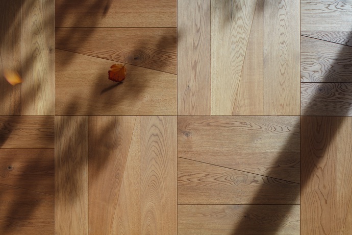  

Dřevěnou podlahu v kuchyni architekti navrhli tak, aby opticky neprodlužovala ani nerozšiřovala prostor. O vzor, kterému na čtvercových kazetách dávají vzniknout nepravidelná prkna, se postarala firma Princ Parket. Vychází z něj také dekor na jídelním stole.
