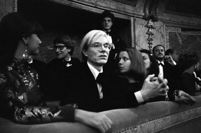 Battle of Versailles, Versailles 1973

Umělec Andy Warhol sedí s návrhářem Yvesem Saint Laurentem, Mary Russell a Pierrem Bergem
