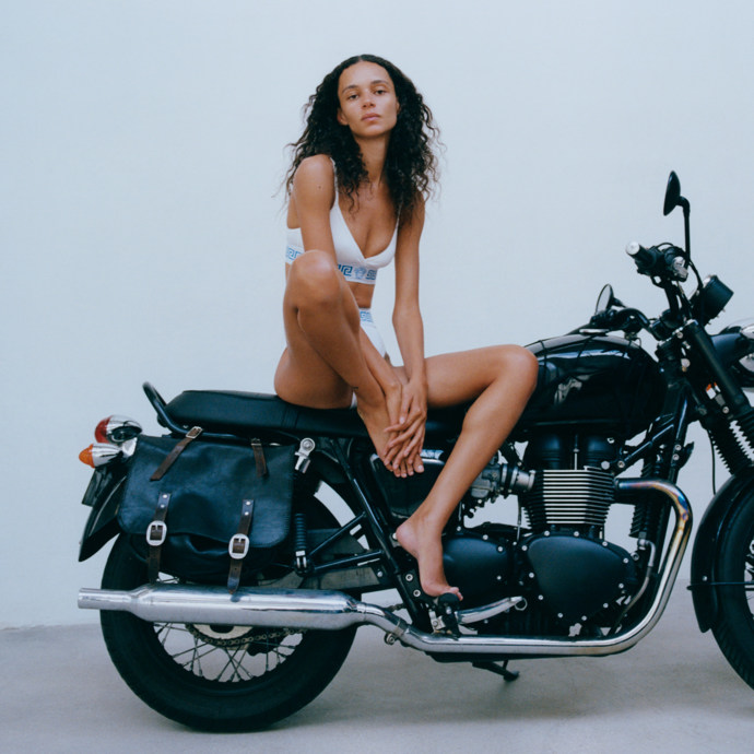 Binx na kole. Fotografovala Stef Mitchell, 2025Binx Walton, modelka a umělkyně, zachycena Stef Mitchell. Proslulá svými strhujícími a intimními portréty, které vyjadřují nezávislost a mládí, a dokonale se tak propojuje s drzým a mladistvým duchem Versace.