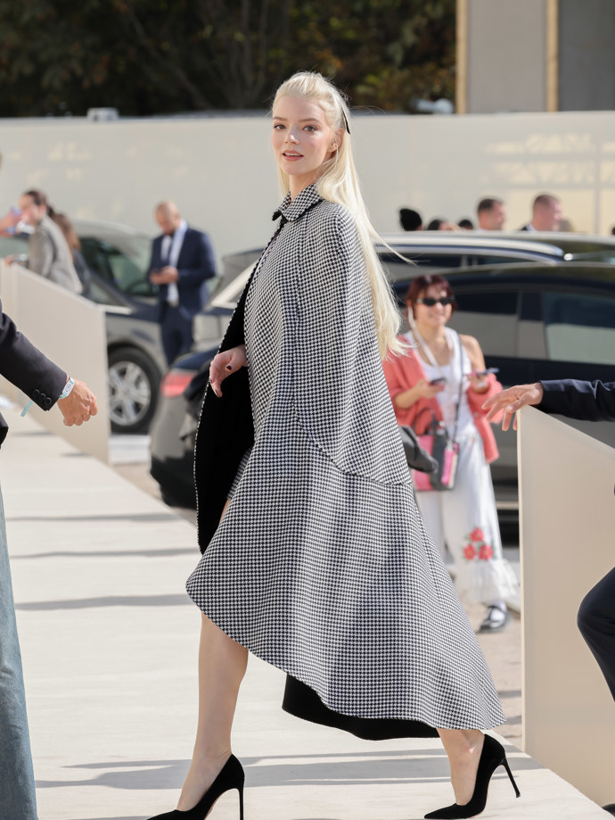 Anya Taylor-Joy vynesla černobílý károvaný plášť v pepito vzoru se sladěnou sukní a bílý halter top. Anya Taylor-Joy vynesla černobílý károvaný plášť v pepito vzoru se sladěnou sukní a bílý halter top.