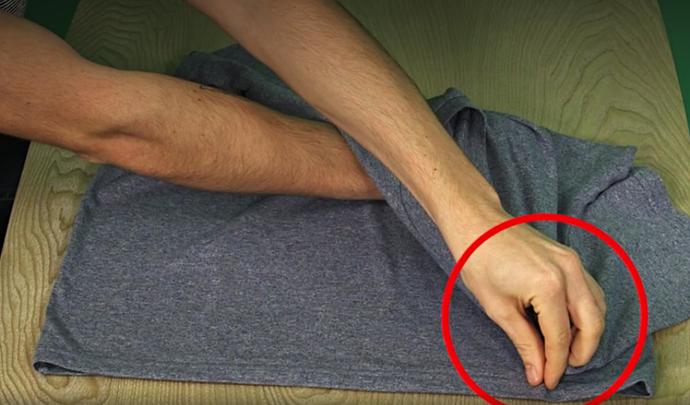 2. Překřižte levou ruku přes pravou a mezi palec a ukazovák přidejte spodní okraj trika. Zakryjete tak pravou ruku, což je správně.