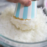 Muffin uchopíme do ruky za košíček a krém „namočíme“ do strouhaného kokosu.