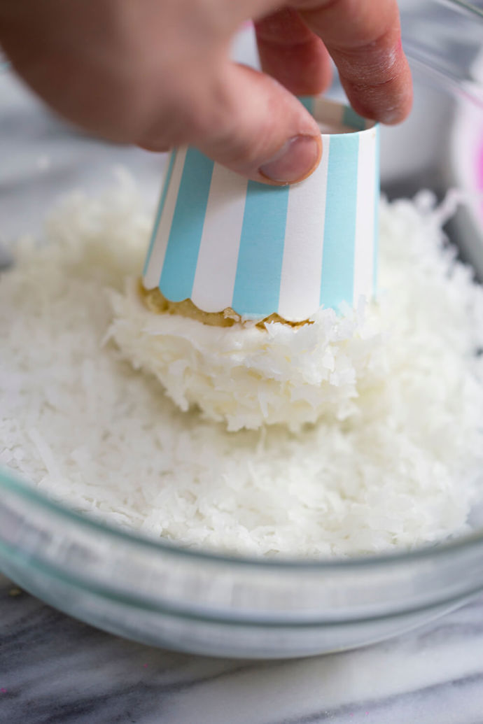 Muffin uchopíme do ruky za košíček a krém „namočíme“ do strouhaného kokosu.