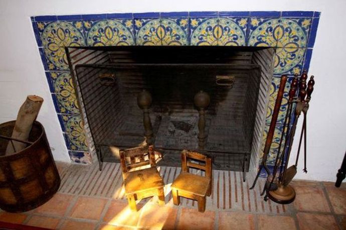 Interiér je zařízen ve stylu španělského venkova a tento dlaždicový rám krbu to dokazuje.