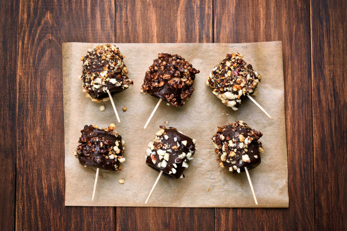 Banán namočený v čokoládě posypaný oříšky - skvělé bezlepkové jednohubky jsou na světě.