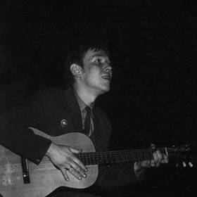 Mladý Jarek hraje na kytaru.