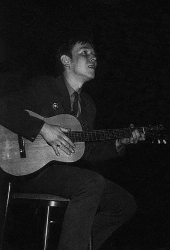 Mladý Jarek hraje na kytaru.