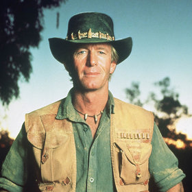 Dundee uspí býka, holou rukou chytí hada a zachrání Sue před krokodýlem. Vždy sebejistá reportérka v jeho přítomnosti ztrácí svou suverenitu a začíná podléhat jeho kouzlu. Když zjistí, že nikdy nebyl ve větším městě, přemluví ho, aby se s ní vydal do New Yorku.