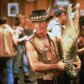 Vypraví se do australského Wakabout Creek, kde ji přivítá Dundeeho společník Walter Reilly. V hospodě jí vypráví patřičně přikrášlenou historku. Vzápětí dovnitř vtrhne Mike s vycpaným krokodýlem, a než se reportérka vzpamatuje, vytáhne ji na parket a během tance stihne pěstí uzemnit muže, který si z něj utahoval. 