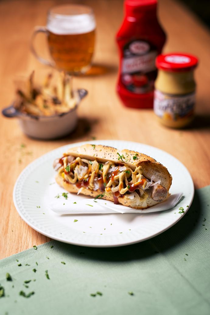 Staročeský hot dog

Suroviny:

4 kvalitní grilovací klobásky (bílé) 
4 bagetky sypané mákem 
100 g kysaného zelí 
2 nakládané okurky 
3 cibule 
klasickou hořčici Spak Gourmet Ketchup Barbecue Spak nakládané jalapeño papričky nakládanou sladkou kukuřici 

Postup: 

Cibuli si nakrájíme na kolečka a orestujeme dozlatova. Okurky a jalapeño papričky si nakrájíme na drobné kostičky. Bagetky si v půlce nakrojíme a opečeme ze všech stran. Poté do nich vložíme klobásky. Na klobásky položíme kysané zelí, orestované cibulové kroužky a zasypeme směsí okurek, jalapeño papriček a kukuřice. Nakonec přidáme barbecue kečup Spak a klasickou hořčici. 