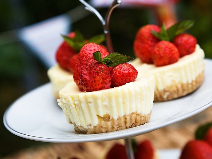 Mini cheesecake:

Suroviny:

130 g máslových sušenek
80 g rozpuštěného másla
360 g sýru Philadelphia (Lučiny)
7 lžic rozpuštěného medu
2 vejce
1/2 kávové lžičky citronové kůry
250 g tvarohu
sezonní ovoce, máta. 

Postup:

Sušenky rozdrtíme v mixéru a přidáme rozpuštěné máslo. Smícháme. Připravíme si formu na muffiny a košíčky. Do košíčků rozdělíme připravenou hmotu a uhladíme. Dáme na 10 minut do lednice.

Mezitím si připravíme sýrovou směs. Vyšleháme sýr Philadephii (Lučinu) s medem. Postupně přidáme vejce, citronovou kůru a na konec tvaroh. Vše prošleháme. 

Směs naplníme do košíčků, uhladíme a dáme péct do předem vyhřáté trouby na 150 °C. Pečeme 18 - 20 minut. Po vyndání z trouby necháme zcela vychladit, poté i s formou přeneseme do lednice, kde necháme alespoň 2 hodiny ztuhnout a vyjmeme z košíčků (nenechávejte v košíčcích přes noc - špatně by se pak odlepovaly!). 