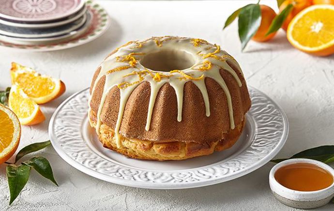 Bábovka s příchutí agáve:

Suroviny:

250 ml sirupu z agáve El Tequito
5 vajec “M“
50 ml vlažné vody
200 ml rostlinného oleje Promienna
350 g polohrubé mouky Castello
12 g kypřicího prášku do pečiva Castello
200 g bílé čokolády Fin Carré
50 ml čerstvé smetany ke šlehání Pilos (33 % tuku)
2 pomeranče (šťáva + kůra)
hrubá mouka Castello na vysypání.

Postup:

Z bílků vyšleháme sníh. Žloutky vyšleháme se 100 ml sirupu z agáve, postupně přilĳeme vlažnou vodu, olej a šleháme dále. Přisypeme mouku s kypřicím práškem a nakonec sníh. Vzniklé těsto přelĳeme do vymazané a hrubou moukou vysypané formy. Pečeme v troubě předehřáté na 150 °C asi 1 hodinu. Po upečení necháme bábovku vychladnout a vyklopíme.

Z rozpuštěné bílé čokolády a horké smetany připravíme polevu, necháme chvilku vychladnout a poté bábovku částečně polĳeme. Pomocí zesteru připravíme nudličky pomerančové kůry, jimiž bábovku ozdobíme.

Bábovku servírujeme s omáčkou, kterou připravíme svařením šťávy ze 2 pomerančů a 150 ml sirupu z agáve.