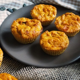 Dýňové muffiny:
Suroviny:
1 hrnek dýně Hokkaido na menší kostky
½ hrnku sýru feta na menší kostky
250 g hladké mouky
70 ml olivového oleje
200 ml bílého jogurtu
50 ml mléka
2 vejce
2 lžičky prášku do pečiva
½ lžičky soli
½ lžičky pepře
1 hrst nasekané petrželové natě nebo čerstvé bazalky.
Postup:
Dýni opečte na troše oleje a nechte vychladnout. Nejprve smícháme všechny suché ingredience – mouku, prášek do pečiva, sůl, pepř. Pak zvlášť smícháme všechny mokré ingredience – olej, jogurt, vejce, mléko – a našleháme. Suché a mokré přísady smícháme a přidáme opečenou dýni Hokkaido, sýr a petrželku, vše krátce promícháme tak, aby místy zůstaly i kousky suché mouky. Naplníme košíčky na muffiny asi 0,5 cm pod okraj a pečeme v troubě vyhřáté na 190 °C asi 25 minut dozlatova.