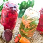 Kvašená zelenina:
Suroviny:
svazek ředkviček
kus zázvoru
3 červené řepy
3 velké mrkve
hlávku zelí
čínské zelí
½ svazku řapíkatého celeru
svazek jarních cibulek
1 palici česneku
drcené čili papričky
sůl.
Postup:
Veškerou zeleninu nakrájíme, popř. nakrouháme. Jeden velký zelný list si ale ponecháme stranou. Ve velké míse vše důkladně promícháme, smícháme s utřeným česnekem, solí a drcenými chilli papričkami, popř. s bylinkami. Důkladně rukama promačkáme, až zelenina pustí vodu. Napěchujeme do velké zavařovací lahve, zalijeme šťávou ze zeleniny, zakryjeme zelným listem a zatížíme vyvařeným kamenem. Zakryjeme talířkem a necháme stát 4–5 dní v kuchyni. Jakmile se přestanou tvořit bublinky, je zelenina připravená ke konzumaci. Obsah lahve přendáme do menších uzavíratelných skleniček a skladujeme ve sklepě anebo v lednici.