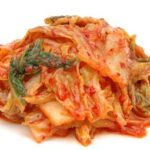 Čínské zelí po korejsku:
Suroviny:
1,2 kg pekingského zelí nakrájeného na proužky nebo čtverce cca 5 x 5cm
40 g mořské soli
370 g jarních cibulek (nakrájených na 5cm kousky)
49 g čerstvého zázvoru (cca 9 cm) nastrouhaného najemno
10 stroužků česneku utřeného nebo rozmačkaného
30 g jemného korejského chilli koření nebo jiného chilli koření
1,5 lžičky krupicového cukru.
Postup:
Ve sklenici rozpusťte ve 2 litrech studené vody 30 g soli. Zelí nasypte do nejméně 2,5litrové nádoby z inertního materiálu (sklo, porcelán, kamenina apod.).
Zalijte osolenou vodou tak, aby bylo ponořené. Zatižte talířem a nechte stát při pokojové teplotě, aby začalo pomalu kvasit. Mají se začít objevovat v tekutině bublinky a zelí mírně zkysne.
Zelí sceďte a nálev uchovejte.
V míse smíchejte zelí, jarní cibulky, zázvor, česnek, chilli koření, cukr a zbývající sůl.
Přeneste do vymyté sklenice a zalijte lákem až k povrchu zeleniny. Zelenina by se měla zatížit třeba sáčkem s vodou apod. Postavte do místnosti, kde teplota nepřesahuje 20 stupňů C, aby zfermetovalo (zkvasilo). Trvá 4-6 dnů. Po vykvašení uzavřete a uchovejte v lednici. Vydrží zde i 3 měsíce.