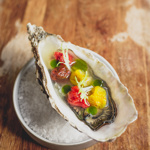 Ústřice se sušenými rajčaty, rajčatovou vodou se zázvorem a bazalkovým olejem.