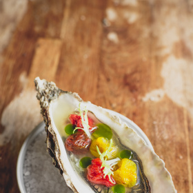 Ústřice se sušenými rajčaty, rajčatovou vodou se zázvorem a bazalkovým olejem.