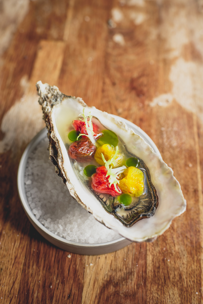 Ústřice se sušenými rajčaty, rajčatovou vodou se zázvorem a bazalkovým olejem.