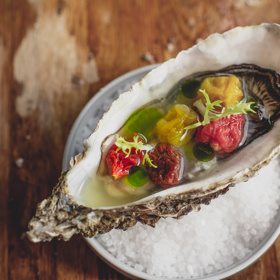 Ústřice se sušenými rajčaty, rajčatovou vodou se zázvorem a bazalkovým olejem.