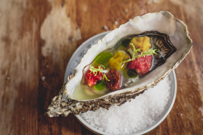 Ústřice se sušenými rajčaty, rajčatovou vodou se zázvorem a bazalkovým olejem.