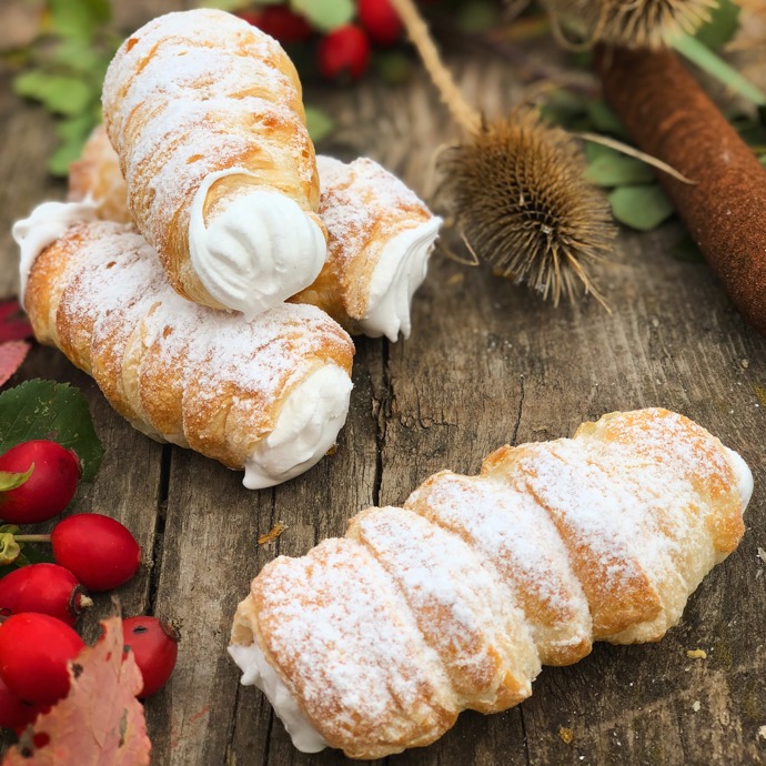 Kremrole:

Suroviny:

250 g máslo
250 g šlehačka
450 g špaldová hladká mouka
1/2 lžičky soli. 

Sníh:
4 bílky
250 g cukr krupice 
1 lžíce citronové šťávy. 

Na dokončení:
1 vejce
50 g cukr moučka. 

POSTUP:
Z másla, mouky a soli uděláme drobenku, do které přidáme vychlazenou smetanu a rychle zpracujeme v těsto. Necháme v chladničce asi 1 hodinu odpočinout. Poté vyválíme na pomoučněném vále na sílu asi 3 mm, nakrájíme rádýlkem či nožem na stejně silné proužky, potřeme vajíčkem a jednotlivé pruhy natáčíme na plechová tvořítka na trubičky. Pečeme v rozehřáté troubě při 180 °C asi 25 až 30 minut. Ještě vlažné sejmeme z tvořítek a necháme dobře vychladnout. Ve vodní lázní či mikrovlnce nahřejeme za stálého míchání bílky, cukr a citronovou šťávu do horka, dokud se krystalky zcela nerozpustí. Poté ušleháme do pevného nadýchaného sněhu. Sněhem naplníme cukrářský sáček s ozdobnou špičkou a kremrole jím naplníme. Před podáváním pocukrujeme.
