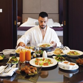 Veškeré náklady na cestu (letenky první třídou, jízdenky, ubytování v nejlepších hotelech, stravování ve známých restauracích apod.) platí milionář.