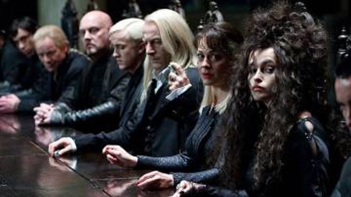 Dostanou se na ministerstvo kouzel, kde ukradnou viteál z rukou Dolores Umridgeové. Byli odhaleni a museli po zisku viteálu utéct do lesa, kde se Ron, zpracovaný zlým účinkem viteálu nahlodávající mysl, po ostré hádce s Harrym a Hermionou oddělí od skupiny... Na snímku jsou herci Tom Felton, Jason Isaacs, Helen McCrory a Helena Bonham Carter.