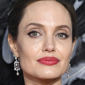 Už tak výrazné rty si neváhá zvýraznit červenou rtěnkou ani Angelina Jolie.