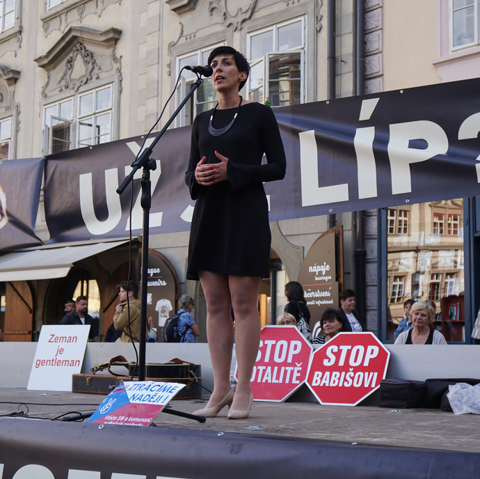 Klasická černá, dobře vybraný náhrdelník. Možná zvolit šaty o trošku delší a výraznější boty, které by tmavým šatům dodaly šmrnc. 