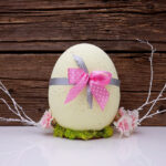 Vajíčka nabarvená přírodními barvivy, třeba kurkumou, která dodá žlutý nádech, mají kouzlo. Dotvořit ho můžete ozdobami, například mašličkou.