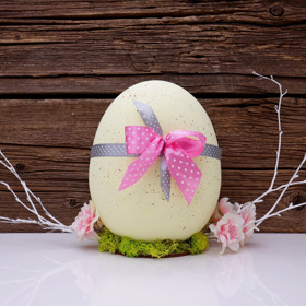 Vajíčka nabarvená přírodními barvivy, třeba kurkumou, která dodá žlutý nádech, mají kouzlo. Dotvořit ho můžete ozdobami, například mašličkou.