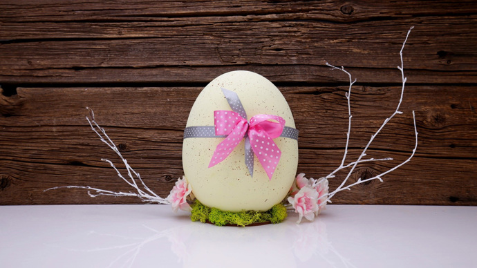 Vajíčka nabarvená přírodními barvivy, třeba kurkumou, která dodá žlutý nádech, mají kouzlo. Dotvořit ho můžete ozdobami, například mašličkou.