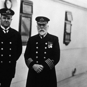 Kapitán Edgar J. Smith (vpravo) a hospodář Hugh Walter McElroy na palubě Titaniku před vyplutím. Pro kapitána to podle některých informací měla být poslední plavba před odchodem do důchodu. Místo toho se ale i s nejmodernějším parníkem té doby za několik dní ocitl na dně Atlantského oceánu. Co všechno tomu předcházelo a kolik chyb posádka udělala?