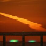 Tento jev způsobují vrstvy atmosféry Země, jenž lámou světlo.