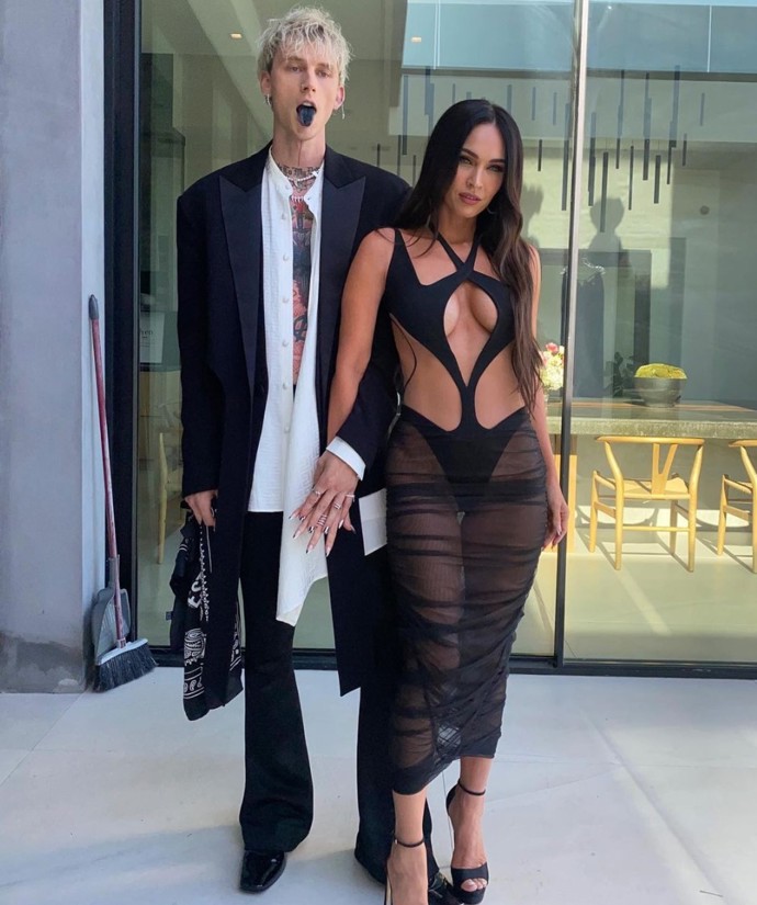 Megan v šatech Mugler, botách Jimmy Choo a manikúrou korespondující s partnerovým lookem.
