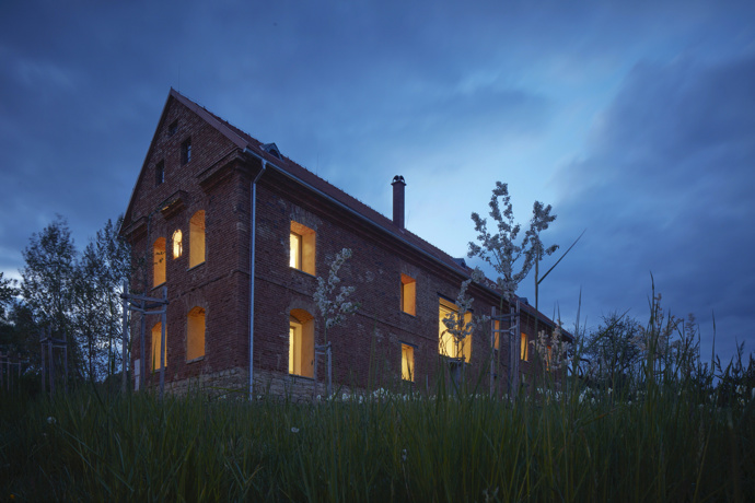 Zvenku majitelé schválně ponechali tělo Sýpky obnažené. Surovost exteriéru kontrastuje s uhlazeným interiérem.