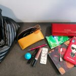 Ukrývá mobilní telefon, sluneční brýle, diář, propisku, magnezium, kabel k telefonu, lesk na rty, řasenku a jelení lůj.