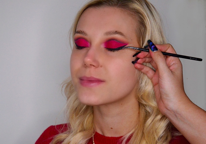 Oční stíny doplňte černou kočičí protáhlou linkou, kterou začněte tvořit od vnějším koutku oka a následně ji dokreslete podél celé linie řas.